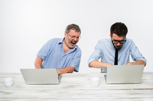 The two colleagues working together at office on white background