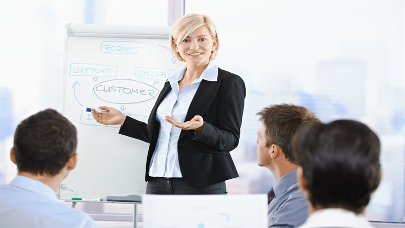 Business people sitting on presentation at office. Businesswoman presenting on whiteboard.