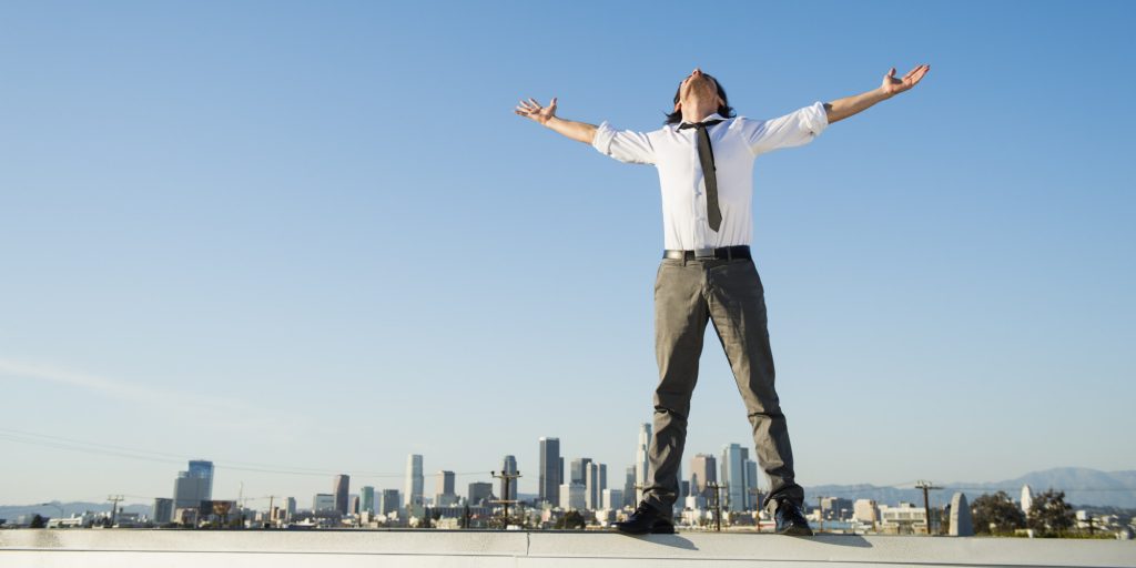 Mixed race businessman standing on urban rooftop