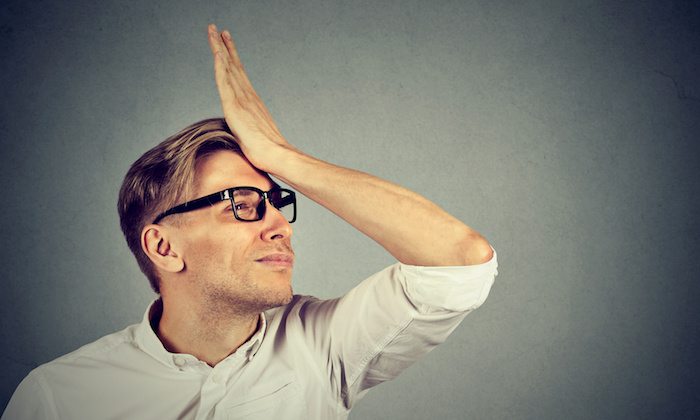 Regrets wrong doing. Silly young man, slapping hand on head having a duh moment isolated on gray background. Negative human emotion facial expression feeling, body language, reaction