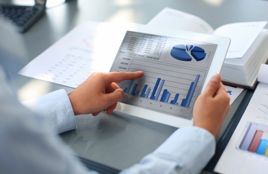 Business person analyzing financial statistics displayed on the tablet screen