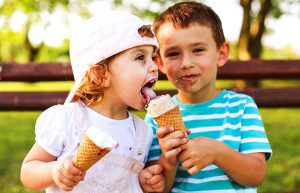 Cute little boy share ice cream with his sister